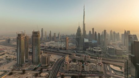 Foto de Panorama showing aerial view of tallest towers in Dubai Downtown skyline and highway before sunset. Financial district and business area in smart urban city. Skyscraper and high-rise buildings - Imagen libre de derechos