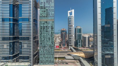 Téléchargez les photos : Panorama montrant la vue aérienne du quartier financier international de Dubaï avec de nombreux gratte-ciel timelapse. Trafic sur la route Cheikh Zayed près des tours à plusieurs étages. Dubai, Émirats arabes unis. - en image libre de droit