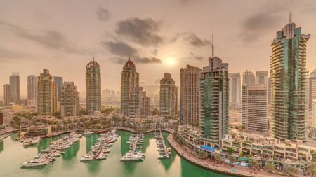 Foto de Salida del sol sobre Dubai Marina distrito turístico de lujo con rascacielos y torres alrededor del canal panorámica aérea. Edificios incidenciales y tráfico en las calles - Imagen libre de derechos