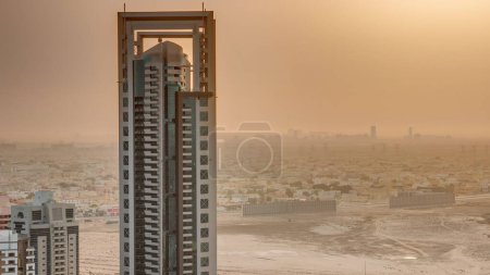 Téléchargez les photos : Lever de soleil sur les gratte-ciel dans le quartier de Barsha Heights et les maisons de villa sur un fond aérien. Skyline Dubaï avec ciel orange le matin - en image libre de droit