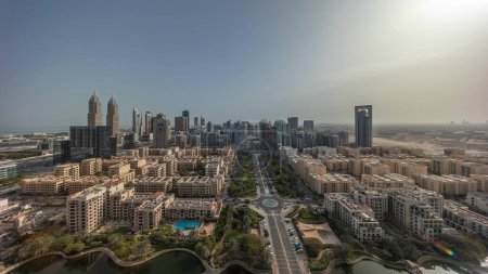 Foto de Panorama de rascacielos en el distrito de Barsha Heights y edificios de poca altura en la antena del distrito de Greens durante todo el día desde el amanecer. Dubai skyline con sombras moviéndose rápido - Imagen libre de derechos
