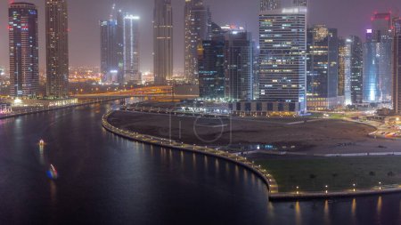Photo for Cityscape of skyscrapers in Dubai Business Bay with water canal aerial day to night transition . Modern skyline with towers and waterfront after sunset. A center of international business - Royalty Free Image