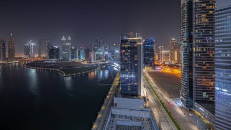 Téléchargez les photos : Panorama showing cityscape of skyscrapers in Dubai Business Bay with water canal aerial night . Modern skyline with illuminated towers and waterfront. A center of international business - en image libre de droit
