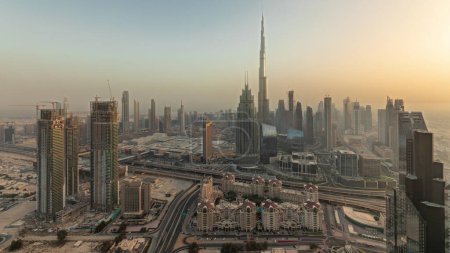 Téléchargez les photos : Panorama showing aerial view of tallest towers in Dubai Downtown skyline and highway  before sunset. Financial district and business area in smart urban city. Skyscraper and high-rise buildings - en image libre de droit