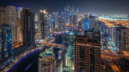 Photo for Panorama showing various skyscrapers in tallest recidential block in Dubai Marina and JDR district aerial night  with artificial canal. Many towers and yachts - Royalty Free Image