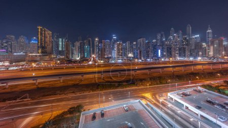 Téléchargez les photos : Panorama of Dubai marina tallest block of skyscrapers day to night transition . Aerial view from JLT district to apartment buildings, hotels and office towers near highway. - en image libre de droit