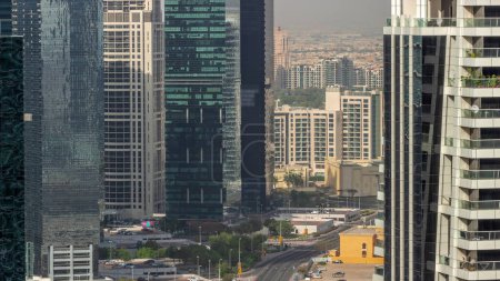 Foto de Edificios residenciales altos en la antena del distrito JLT, parte del distrito de usos mixtos del centro de productos básicos de Dubái. Tráfico en una carretera - Imagen libre de derechos