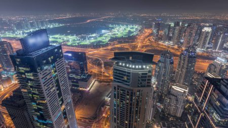 Téléchargez les photos : Panorama du port de plaisance de Dubaï avec gratte-ciel JLT et golf, Dubaï, Émirats arabes unis. Vue aérienne depuis les tours supérieures. Éclairage des lumières de ville - en image libre de droit