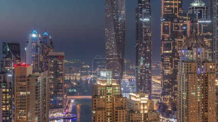 Photo for Skyscrapers of Dubai Marina with illuminated highest residential buildings day to night transition after sunset. Aerial top view from JLT district - Royalty Free Image