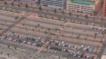 Foto de Gran estacionamiento cerca del centro comercial lleno de muchos coches vista aérea. Los vehículos entran y salen durante todo el día con sombras en movimiento - Imagen libre de derechos
