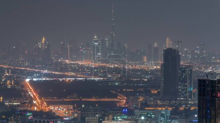 Foto de Dubai Downtown con el horizonte del distrito financiero fila de rascacielos con torre más alta noche aérea. Vista general en una distancia lejana de la azotea del puerto deportivo de Dubai. Villa casas después del atardecer. EAU - Imagen libre de derechos