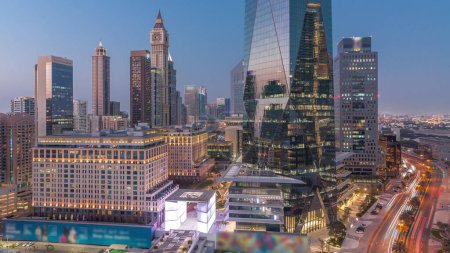 Téléchargez les photos : Dubai International Quartier financier transition jour-nuit. Vue aérienne des tours de bureaux d'affaires après le coucher du soleil. gratte-ciel avec hôtels et centres commerciaux près du centre-ville - en image libre de droit