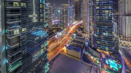 Photo for Panorama showing Dubai Marina and JBR area and the famous Ferris Wheel aerial night and illuminated skyscrapers and traffic on streets - Royalty Free Image
