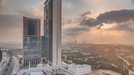 Foto de Salida del sol en el distrito financiero internacional de Dubai transición. Vista aérea de las torres de oficinas de negocios por la mañana. Rascacielos con hoteles cerca del centro - Imagen libre de derechos
