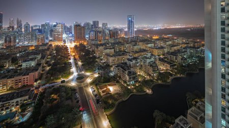 Foto de Panorama mostrando rascacielos en el distrito de Barsha Heights y edificios de poca altura en la noche aérea del distrito de Greens. Dubai skyline con palmeras y árboles - Imagen libre de derechos