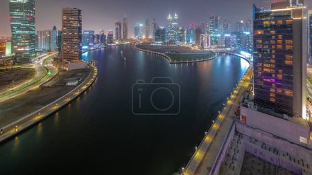 Foto de Paisaje urbano de rascacielos en Dubai Business Bay con vista panorámica de transición día a noche del canal de agua. skyline moderno con torres y paseo marítimo después de la puesta del sol. Un centro de negocios internacionales - Imagen libre de derechos