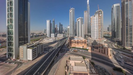 Foto de Vista panorámica aérea del horizonte del centro de Dubái con muchas torres timelapse. Las sombras se mueven rápido por la noche. Área de negocios en la ciudad urbana inteligente. Rascacielos y edificios de gran altura desde arriba, Emiratos Árabes Unidos. - Imagen libre de derechos