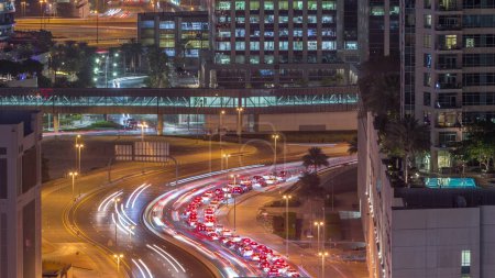 Foto de Vista aérea superior de la concurrida intersección de carreteras y cruces de tráfico en el centro de Dubái ciudad noche timelapse. Diseño moderno de construcción de encrucijadas y autopistas para evitar atascos de tráfico. Muchos coches de conducción - Imagen libre de derechos