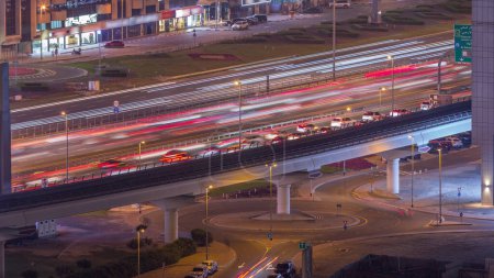 Téléchargez les photos : Vue aérienne du cheikh occupé zayed carrefours routiers et de la circulation dans la ville de Dubaï nuit timelapse. Construction moderne de carrefours et d'autoroutes pour éviter les embouteillages. Conduite de voitures au rond-point - en image libre de droit