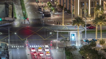 Foto de Vista aérea superior de la concurrida intersección de carreteras y cruces de tráfico en Dubai downrown noche timelapse. Diseño moderno de construcción de encrucijadas y calles para evitar atascos de tráfico. Muchos coches de conducción - Imagen libre de derechos