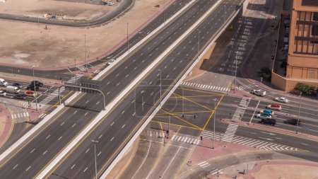 Foto de Vista aérea superior de la concurrida intersección de carreteras y cruces de tráfico en Dubai ciudad timelapse. Diseño moderno de construcción de encrucijadas y autopistas para evitar atascos de tráfico. Muchos coches de conducción - Imagen libre de derechos