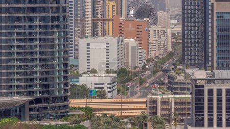 Foto de Dubai International Financial district aerial timelapse (en inglés). Rascacielos con hoteles y museo cerca del centro. Vista de cerca del tráfico por carretera entre las torres de negocios y las oficinas financieras en un día soleado - Imagen libre de derechos