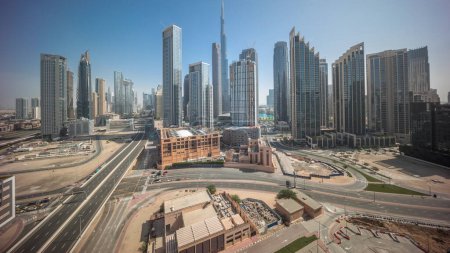 Téléchargez les photos : Vue aérienne de Dubai Downtown skyline avec de nombreuses tours panorama timelapse pendant toute la journée. Zone d'affaires dans la ville urbaine intelligente. gratte-ciel et immeubles de grande hauteur avec ombres mobiles d'en haut, EAU. - en image libre de droit
