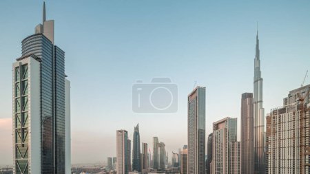 Foto de Vista aérea del horizonte del centro de Dubái con muchas de las torres más altas del día a la noche. Área de negocios en la ciudad urbana inteligente. Rascacielos y edificios de gran altura desde arriba después del atardecer, EAU. - Imagen libre de derechos