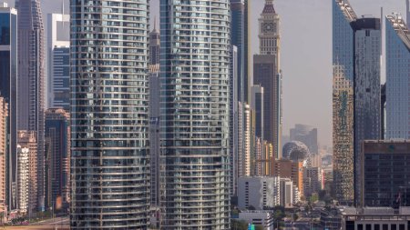 Foto de Dubai International Financial district aerial timelapse (en inglés). Rascacielos con hoteles y museo cerca del centro. Vista de cerca de las largas sombras que se mudan en las torres de negocios y oficinas temprano en la mañana - Imagen libre de derechos