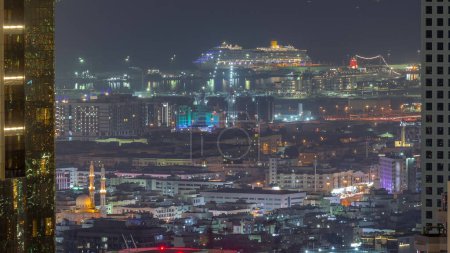 Téléchargez les photos : Vue aérienne des maisons d'appartements et villas dans la ville de Dubaï près du timelapse nocturne du centre-ville. Port maritime et chantier de construction sur fond. Émirats arabes unis - en image libre de droit