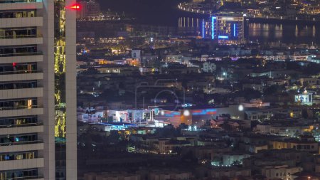 Téléchargez les photos : Vue aérienne des maisons d'appartements et villas dans la ville de Dubaï près du timelapse nocturne du centre-ville. Île artificielle sur un fond. Émirats arabes unis - en image libre de droit