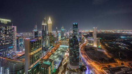 Photo for Skyline view of the high-rise buildings on Sheikh Zayed Road in Dubai aerial night panoramic timelapse, UAE. Illuminated skyscrapers in International Financial Centre from above - Royalty Free Image