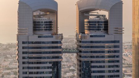 Foto de Vista de cerca de los edificios de gran altura en Sheikh Zayed Road en Dubai timelapse aéreo, Emiratos Árabes Unidos. Rascacielos arriba en el centro financiero del Centro Financiero Internacional desde arriba durante la puesta del sol - Imagen libre de derechos
