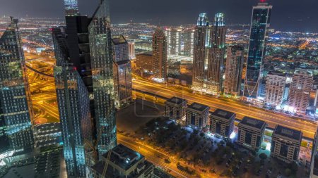 Photo for High-rise buildings on Sheikh Zayed Road in Dubai aerial night to day transition timelapse, UAE. Skyscrapers in international financial district from above. City walk houses and villas on background - Royalty Free Image