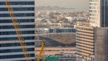 Foto de Rascacielos y casas privadas cerca de la estación de metro de Business Bay junto a Sheikh Zayed Road en Dubai timelapse. Vista real con grúas en obra - Imagen libre de derechos