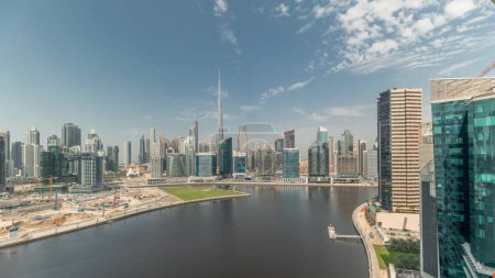 Foto de Panorama que muestra una vista aérea de Dubai Business Bay y el centro de la ciudad con los diversos rascacielos y torres a lo largo de la costa en el timelapse canal. Gran obra de construcción con grúas - Imagen libre de derechos