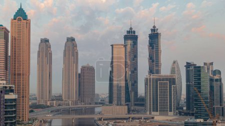 Foto de Paisaje urbano con rascacielos de Dubai Business Bay y canal de agua aérea mañana timelapse. skyline moderno con torres residenciales y de oficina durante el amanecer. Sol reflejado desde la superficie de vidrio - Imagen libre de derechos