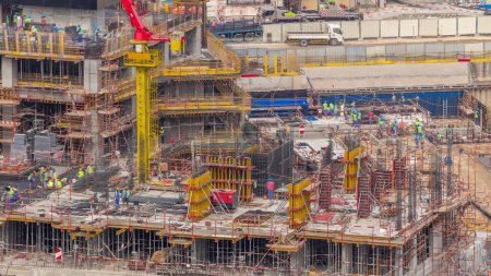 Foto de Gran obra de construcción con grúas de trabajo timelapse. Vista aérea superior de cerca de gran desarrollo del distrito residencial y de oficinas con muchos trabajadores en Business Bay, Dubai - Imagen libre de derechos