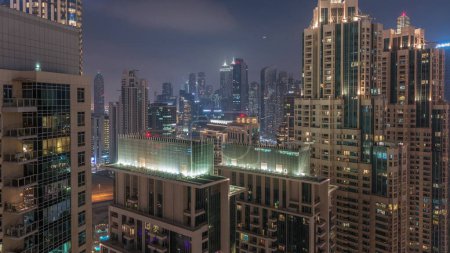 Photo for Dubai skyscrapers with golden sky over business bay district day to night transition. Aerial view from downtown in United Arab Emirates. Colorful clouds - Royalty Free Image