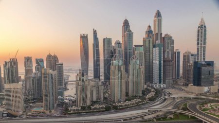 Téléchargez les photos : Dubaï Marina carrefour autoroutier spaghetti soir de jonction. Les gratte-ciel les plus hauts avec réflexion du soleil couchant sur une surface en verre. Vue aérienne du quartier JLT au coucher du soleil - en image libre de droit