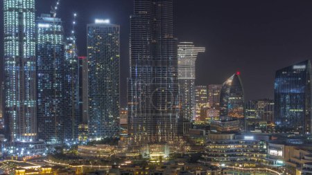 Photo for Dubai Downtown during all night with tallest skyscraper and other illuminated towers with lights turning off view from the top in Dubai, United Arab Emirates. Traditional houses of old town - Royalty Free Image