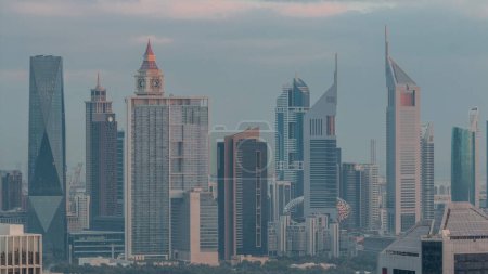 Foto de Filas de rascacielos en el distrito financiero de Dubai transición aérea noche a día. Vista panorámica de muchas torres iluminadas desde el distrito de Business Bay antes del amanecer - Imagen libre de derechos