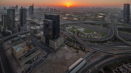 Photo for Aerial panoramic view of media city and al barsha heights district with golf course from Dubai marina during sunrise. Towers and skyscrapers with traffic on a highway crossroad from above - Royalty Free Image