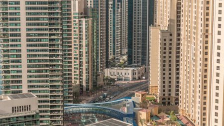 Téléchargez les photos : Vue d'ensemble de JBR et Dubai Marina skyline avec gratte-ciel modernes gratte-ciel front de mer vivant appartements aériens. Trafic routier à l'intersection et à la passerelle tôt le matin au lever du soleil - en image libre de droit