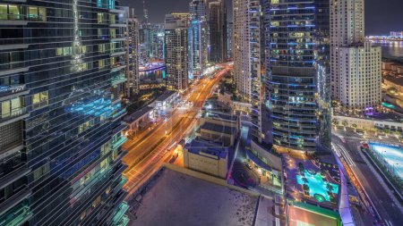 Photo for Panorama showing Dubai Marina and JBR area and the famous Ferris Wheel aerial night and illuminated skyscrapers and traffic on streets - Royalty Free Image