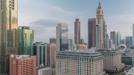 Foto de Distrito Financiero Internacional de Dubái transición día a día. Vista aérea de las torres de oficinas de negocios antes del amanecer. Rascacielos iluminados con hoteles cerca del centro - Imagen libre de derechos