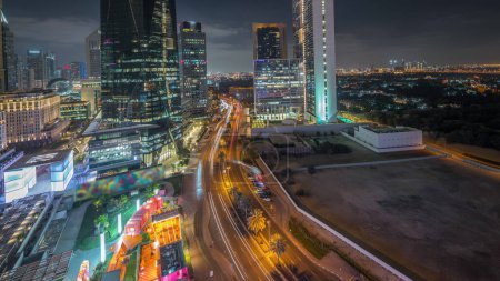 Foto de Panorama mostrando la noche del distrito financiero internacional de Dubai. Vista aérea de las torres de oficinas de negocios. Rascacielos iluminados con hoteles y centros comerciales cerca del centro - Imagen libre de derechos