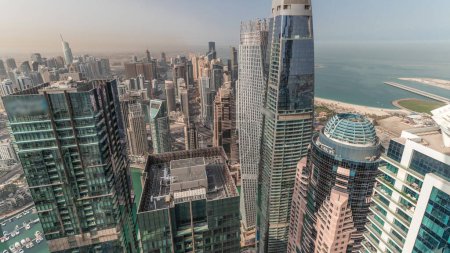 Téléchargez les photos : Panorama montrant Dubai Marina et JLT avec quartier JBR le matin. Trafic routier entre gratte-ciel aérien. Tours modernes et chantier de construction. Yachts flottant dans le port - en image libre de droit