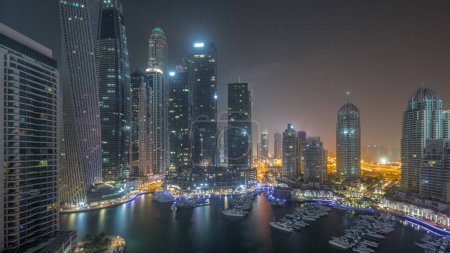 Téléchargez les photos : Dubai Marina plus grands gratte-ciel et yachts dans l'air du port pendant toute la nuit avec des lumières éteintes. Vue sur les immeubles d'appartements, les hôtels et les immeubles de bureaux, développement résidentiel moderne des EAU - en image libre de droit