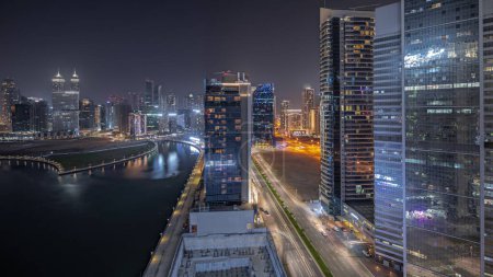 Téléchargez les photos : Panorama montrant le paysage urbain des gratte-ciel de Dubai Business Bay avec canal d'eau de nuit aérienne. Skyline moderne avec des tours éclairées et front de mer. Un centre d'affaires international - en image libre de droit
